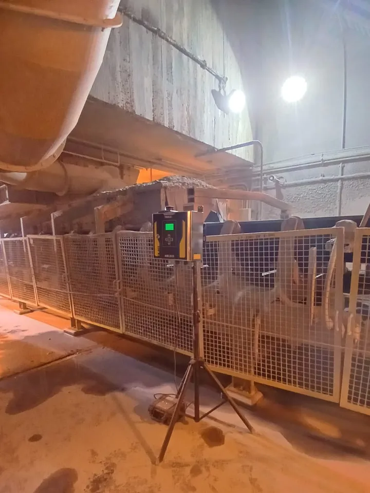 Monitor TROLEX AIR XD sobre trípode midiendo polvo respirable junto a una faja transportadora en interior mina